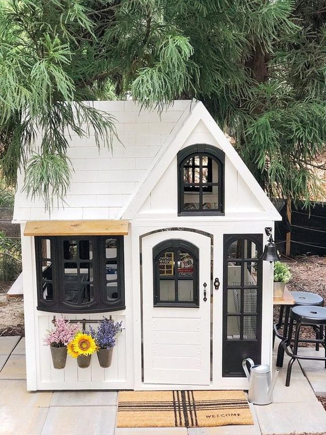 White Playhouse Among Blooming Gardens