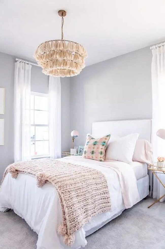Sculptural Chandeliers Above Neutral Bed