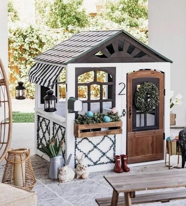 Black-Trimmed Playhouse With Striped Awning