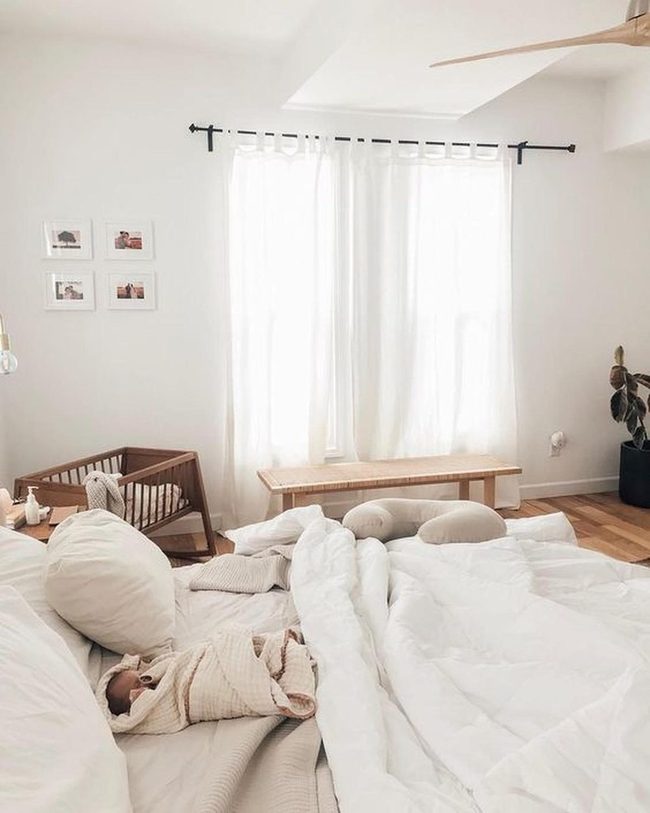Sunlit White Bedroom With Wooden Crib