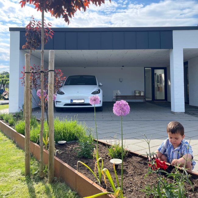 Spacious Carport Harmoniously Blending With Garden Elements